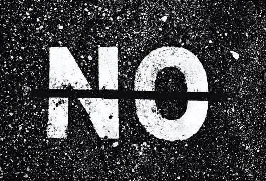 Mot "NO" Peint au Pochoir Blanc sur Asphalte Noir &agrave; Haut Contraste pour &Eacute;v&eacute;nements, Articles Conceptuels et Banni&egrave;res