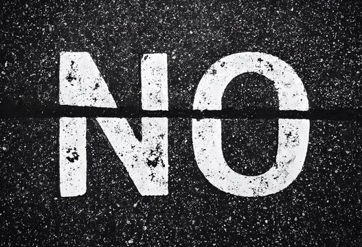 Mot "NO" Peint au Pochoir Blanc sur Asphalte Noir &agrave; Haut Contraste pour &Eacute;v&eacute;nements, Articles Conceptuels et Banni&egrave;res