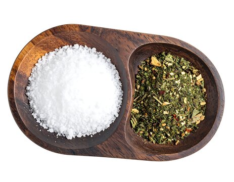 Coarse sea salt and dried green herbs seasoning in divided wooden bowl isolated on white background
