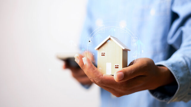 Real estate investment concept showing a miniature house held by a professional, with financial growth icons, mortgage planning,