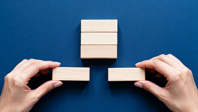 Hand Placing Wooden Block with SOMETHING NEW IS COMING Text on Deep Blue Background &mdash; New Beginning Concept