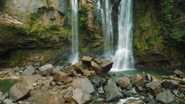 Nauyaca waterfalls cascading over rocky cliffs into tropical pool in Costa Rica
