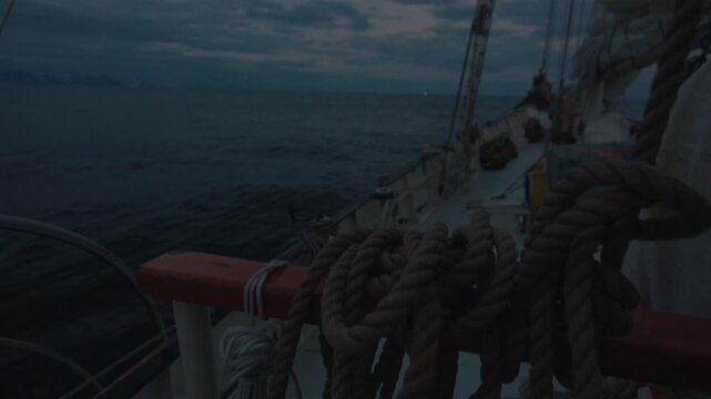 Sailing boat sails in the sea at twilight. Details of the sailing boat
