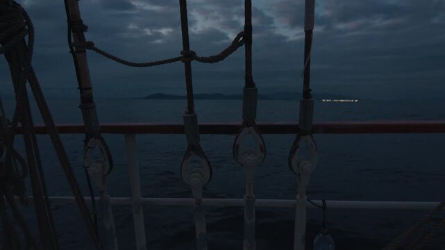 Sailing boat sails in the sea at twilight. Details of the sailing boat