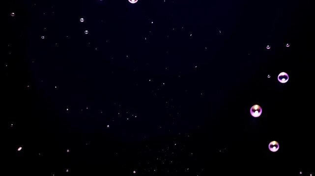 Colorful bubbles floating in a dark space, showcasing a mesmerizing progression of reflections and light patterns as they drift and interact with each other