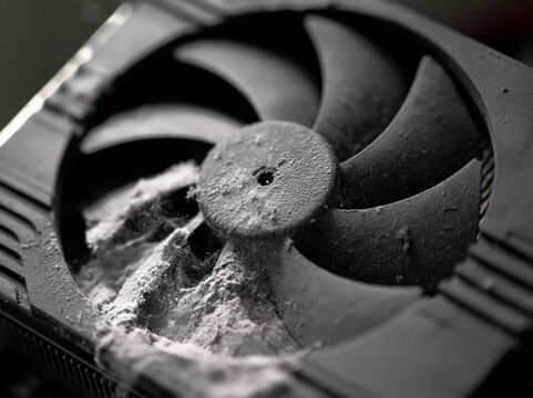 A dirty computer fan covered in dust, showing the need for cleaning and maintenance. The fan blades are partially obscured by the accumulated dust, highlighting neglect