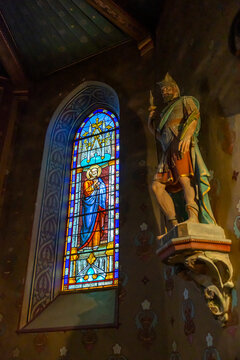 Stained glass window beside a statue of Saint Maurice, Gers, Saint Georges, France