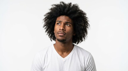 Fototapeta premium Thoughtful Young Black Man with Afro Hairstyle Looking Up in Contemplation Against White Background