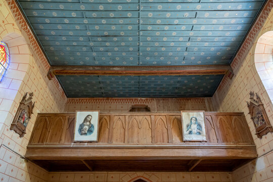View of a wooden choir loft with framed religious portraits and painted ceiling, Gers, Saint Georges, France