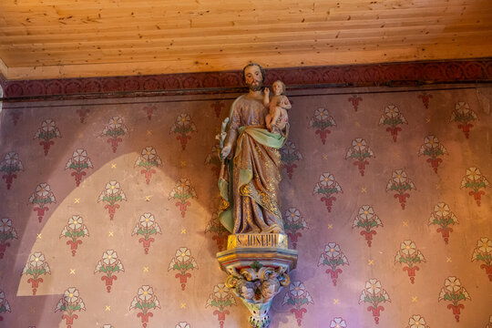 Statue of Saint Joseph holding the Child Jesus on a wall bracket, Gers, Saint Georges, France