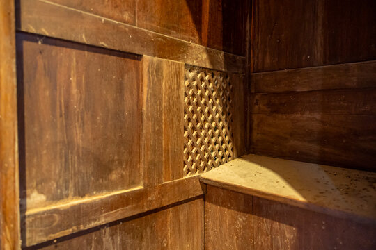 Close-up of wooden paneling and a lattice grille inside a confessional booth, Gers, Saint Georges, France