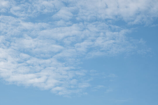 Clear blue sky with scattered wispy clouds, soft sunlight and a serene atmosphere highlighting natural beauty.