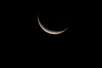 Minimalist shot of a delicate crescent moon glowing in the expansive sky © CesareFerrari
