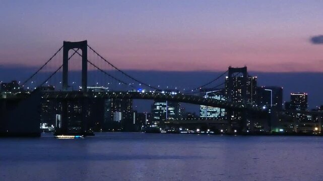 A static long-shot video of the Rainbow Bridge in Minato Ward, Tokyo, at sunset.