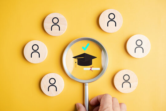 Graduate recruitment education qualification and alumni candidate selection. Hand holding magnifier zooming on graduation cap and certificate.