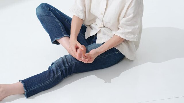 A woman massaging the soles of feet. Massage, foot care, acupressure, corns, calluses, warts, athlete's foot, arches, plantar fasciitis, flat feet.