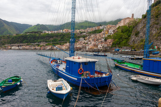 The little harbour of Scilla, Calabria, Italy, with two swordfishing boats (passarelle) moored to the quayside and displaying their tall spotter towers and long harpooning gantries (passarella)