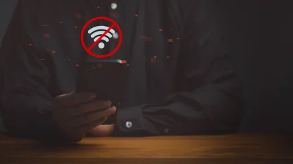 Fotobehang Sportwinkel Man holding a smartphone with a red no wifi icon. This offline digital technology concept shows internet network connection error, communication problem, and disconnected signal.  © ParinPIX
