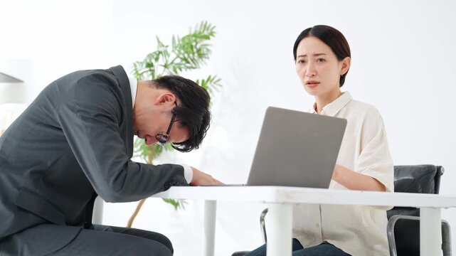面談する男女。接客、相談、悩み、疑問、困る、不安、心配、ビジネス、PC、説明、顧客、謝罪、女性、男