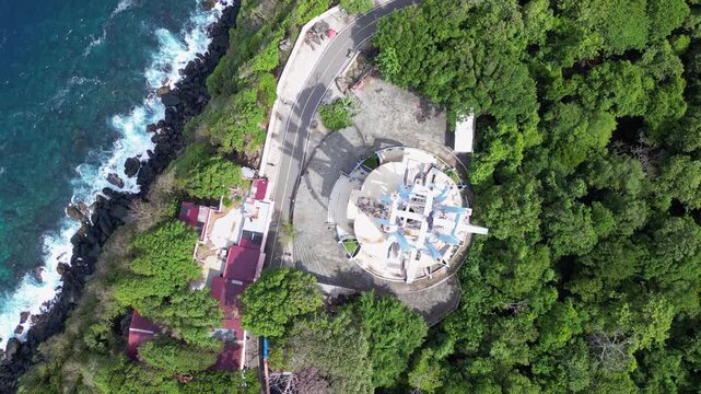 Pulau Weh, Indonesia : Top down aerial drone footage above 0 kilometer monument in Weh island of Aceh, Indonesia surrounded by rain forest. Taken with forward motion showing wave from Andaman sea 