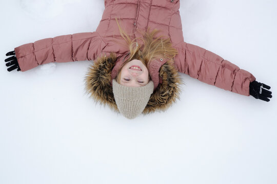 Top view of a child making an angel on the snow