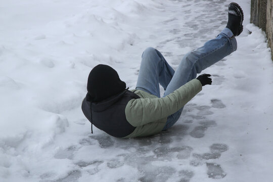 Winter Slip and Risk of Fall Accidents in Winter - a woman slips on an ice-covered road is a common winter hazard, leading to potential injuries