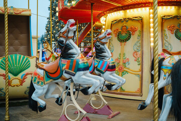 Detailed vintage carousel horses and colorful carriage on a festive illuminated merry go round © reddish