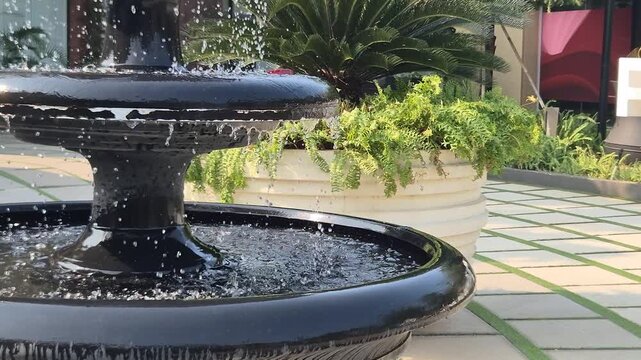 A striking black fountain stands at Indonesia District Center in Pantai Indah Kapuk (PIK), Jakarta, surrounded by a modern commercial and urban environment.