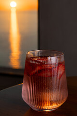 Obraz premium Strawberry lemonade with lime and fresh mint overlooking the sea at sunset 