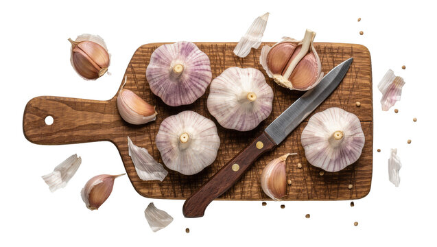 Whole and peeled garlic bulbs with a knife on a wooden cutting board, isolated on transparent background