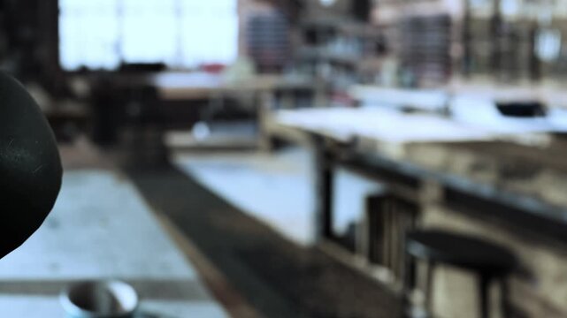 In a warm, inviting workshop, scattered tools and materials lie on wooden tables. Sunlight filters through large windows, illuminating the space where creativity thrives.