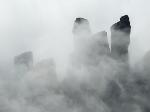 Aerial view of Punta Carina rocky peaks emerging from thick mountain fog in the Apuan Alps, Minucciano, Toscana, Italy.