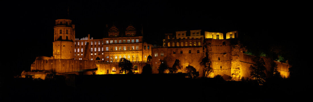 Schloss Heidelberg, the historic European castle in Heidelberg, Germany, illuminated in the night. A panorama with dark background. 