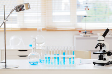 Scientific research and medical innovation, laboratory equipment with test tubes and microscope on...