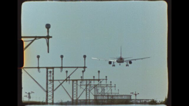 Airplane descends above airport approach lights with landing gear down, filmed on Super 8 film