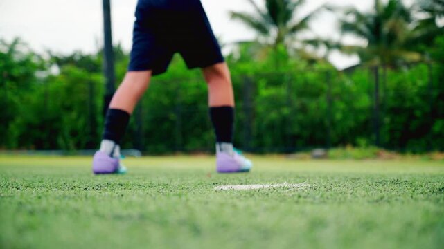 Kid boy leg kicking soccer ball on green grass field action. conceptual metaphor for youth sports training team competition fitness health wellness and active lifestyle	