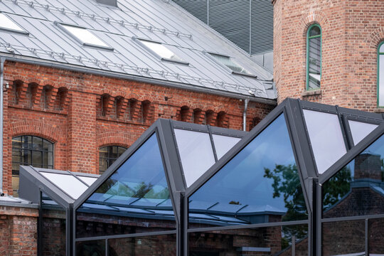 Historic brick architecture and modern glass canopy meet in Oslo Norway creating a layered urban scene of heritage and contemporary design
