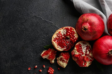 Obraz premium Fresh ripe pomegranates with seeds on dark background