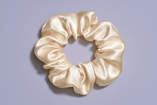 Soft champagne colored silk scrunchie creating a stylish hair accessory