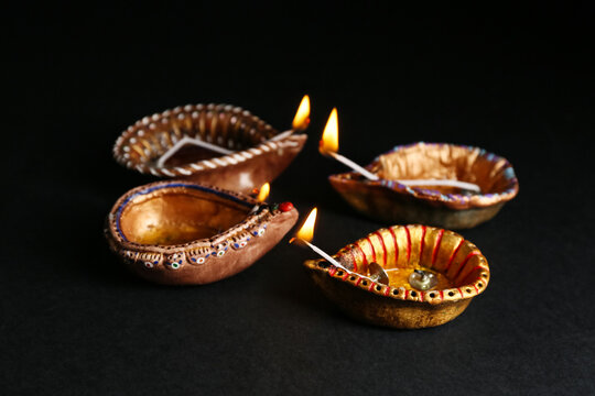 Diya lamps on black background. Divaly celebration
