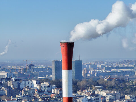 Aerial view of a red and white industrial chimney emitting smoke over the urban cityscape of Belgrade, City of Belgrade, Serbia.
