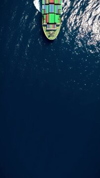 Aerial overhed view of a container cargo ship sailing over the open ocean