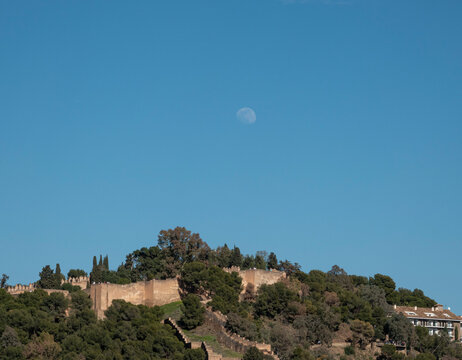 Alcazaba fortress and Gibralfaro hill with the moon above M&aacute;laga, Spain