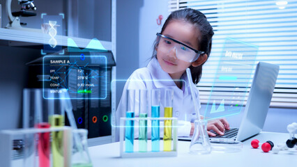 Asian girl student wearing safety goggles using laptop to analyze digital holographic dna data for...