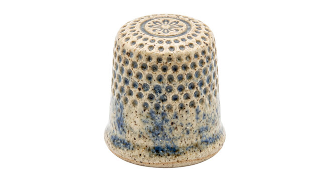 Handcrafted ceramic thimble with intricate dot pattern and floral top detail