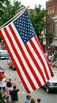 The american flag is waving with pride and honor during a lively town parade as people watch from the roadside