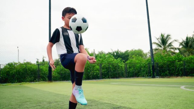 Kid boy leg kicking soccer ball on green grass field action. conceptual metaphor for youth sports training team competition fitness health wellness and active lifestyle	