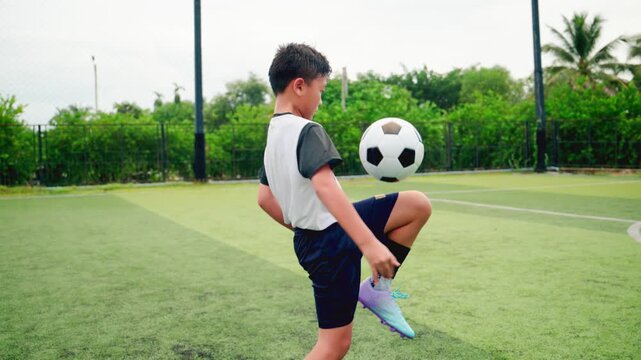 Kid boy leg kicking soccer ball on green grass field action. conceptual metaphor for youth sports training team competition fitness health wellness and active lifestyle	