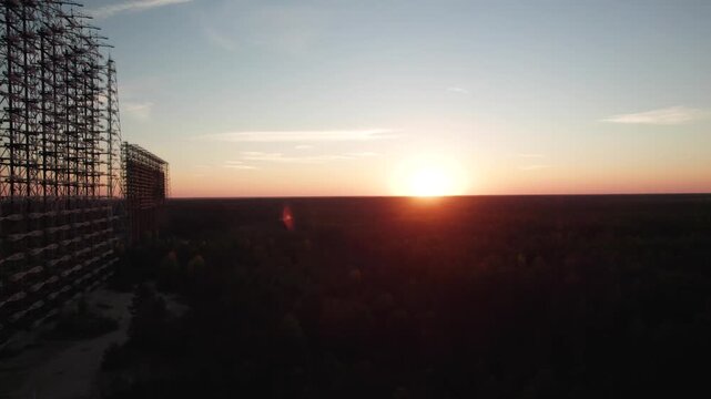 Aerial view of the Duga 1 Receiver radar structure silhouetted against a sunset sky over the forest in Chernobyl, Kyiv Oblast, Ukraine.