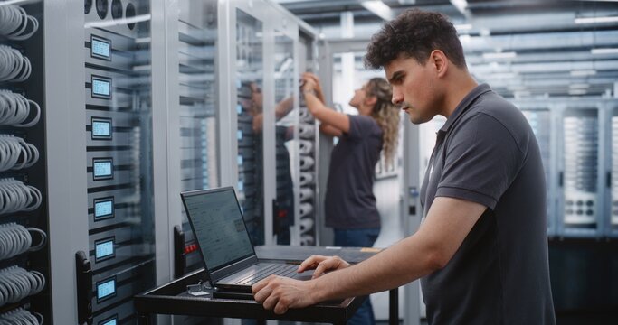 Male IT Specialist Investigates Critical Thermal Incident Using Linux Terminal, Checking System Status and Applying Emergency Console Commands. Female Colleague Services Another Server Cabinet Nearby.